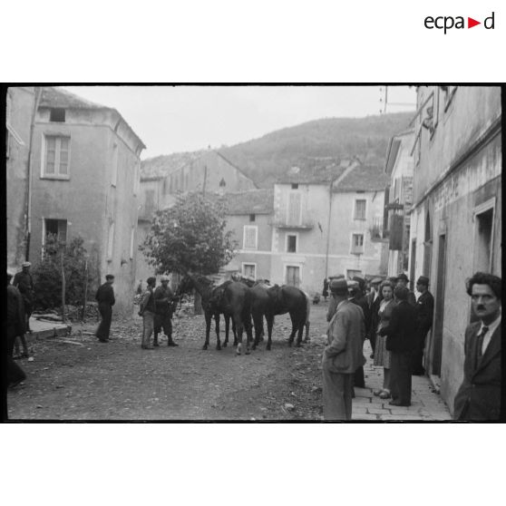 Des soldats italiens se trouvent dans une rue de la commune, au milieu de la population civile.