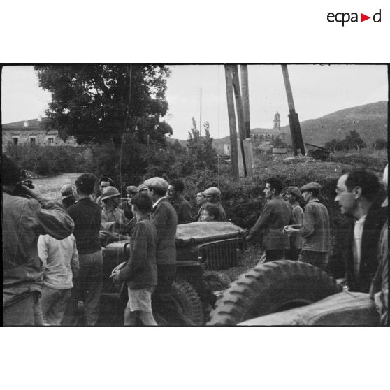 Des habitants du village de Patrimonio accueillent l'équipage d'une jeep Ford GPW (probablement du 4e régiment de spahis marocains).