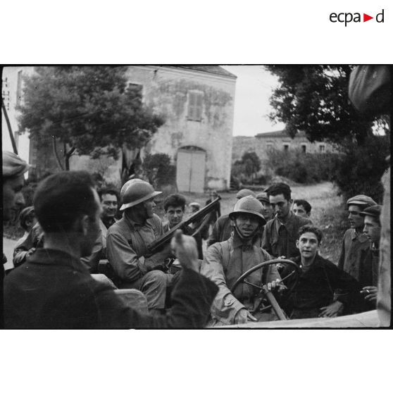 Des habitants du village de Patrimonio accueillent l'équipage d'une jeep Ford GPW en mission de reconnaissance.