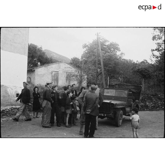 Des habitants du village de Patrimonio accueillent l'équipage d'une jeep Ford GPW (probablement du 4e régiment de spahis marocains).