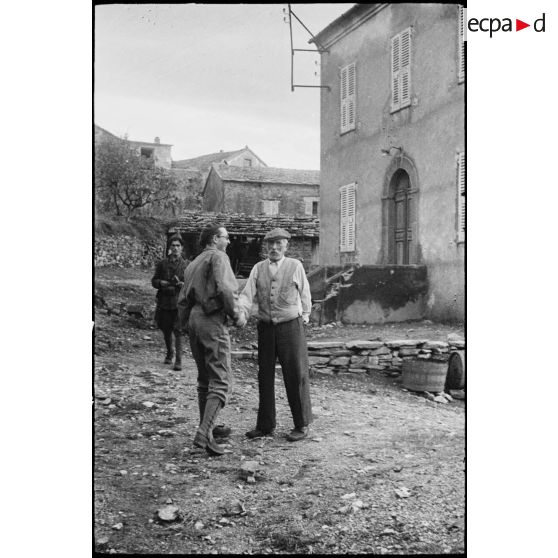 Un habitant du village de Patrimonio libéré discute avec le lieutenant Albert Plécy, officier de presse et photographe du SCA (Service cinématographique de l'armée).