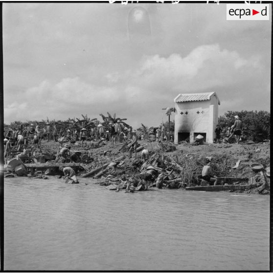 Récupération de la ferraille, jetée par la 11e CMRM (compagnie moyenne de réparation du matériel), dans le fleuve Rouge.