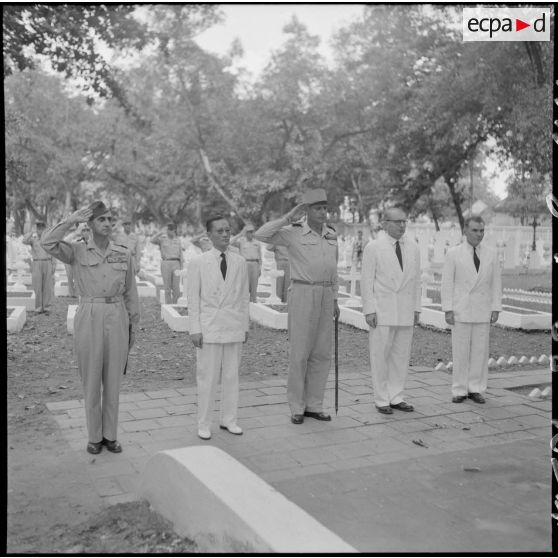 Dans un cimetière d'Hanoï, le général de Castries, M. le Gouverneur du Nord-Vietnam, le général Cogny, M. Bordaz et M. Compain rendent les honneurs aux soldats morts en Indochine.