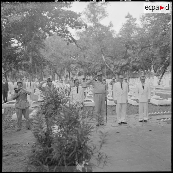 Dans un cimetière d'Hanoï, le général de Castries, M. le Gouverneur du Nord-Vietnam, le général Cogny, M. Bordaz et M. Compain rendent les honneurs aux soldats morts en Indochine.