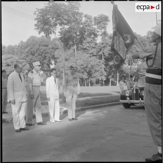 Le général de Castries, M. le Gouverneur du Nord-Vietnam, le général Cogny et M. Bordaz devant le drapeau français.