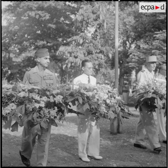 Le général de Castries, M. le Gouverneur du Nord-Vietnam et le général Cogny s'aprêtent à déposer des gerbes de fleurs.