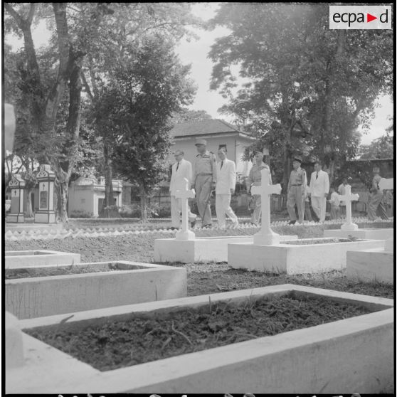 Le général de Castries, M. le Gouverneur du Nord-Vietnam, le général Cogny, M. Bordaz et M. Compain dans une allée d'un cimetière d'Hanoï.