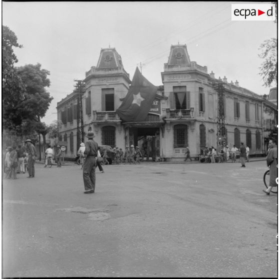 Le drapeau Viêt-minh flotte sur un bâtiment à l'architecture coloniale.