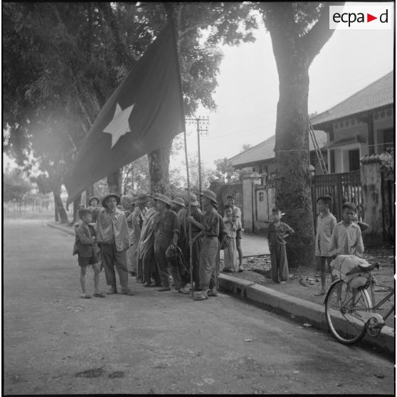 Enfants et hommes des troupes de l'APVN (Armée populaire vietnamienne)	 dans une rue d'Hanoï.