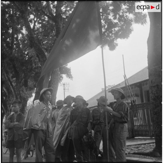 Enfant et hommes des troupes de l'APVN (Armée populaire vietnamienne)	 dans une rue d'Hanoï.