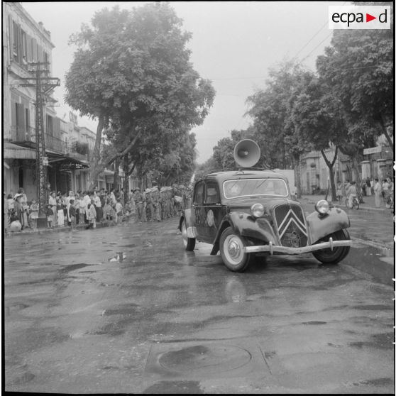 Voiture Viêt-minh avec haut-parleur roulant dans une rue d'Hanoï.