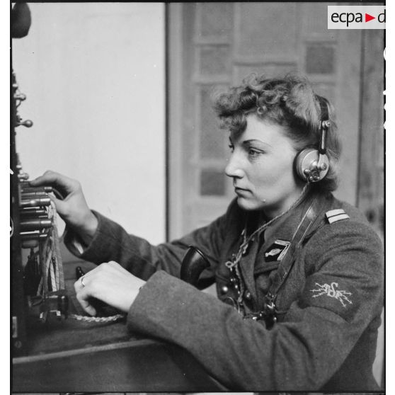 Portrait d'un lieutenant du corps féminin des transmissions utilisant un central téléphonique dans un centre de formation.