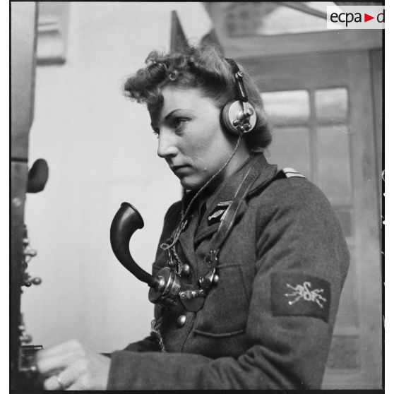 Portrait d'un lieutenant du corps féminin des transmissions utilisant un central téléphonique dans un centre de formation.