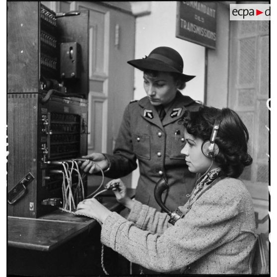 Un lieutenant du corps féminin des transmissions forme une élève à l'utilisation d'un central téléphonique dans un centre de formation.