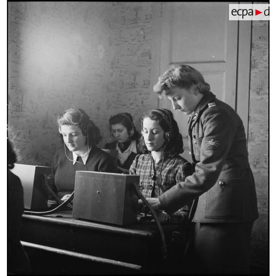 Un lieutenant du corps féminin des transmissions forme des élèves à la télétypie dans un centre de formation.