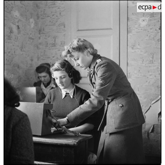 Un lieutenant du corps féminin des transmissions forme des élèves à la télétypie dans un centre de formation.