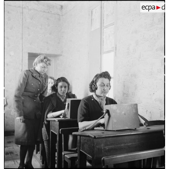 Un lieutenant du corps féminin des transmissions forme des élèves à la télétypie dans un centre de formation.