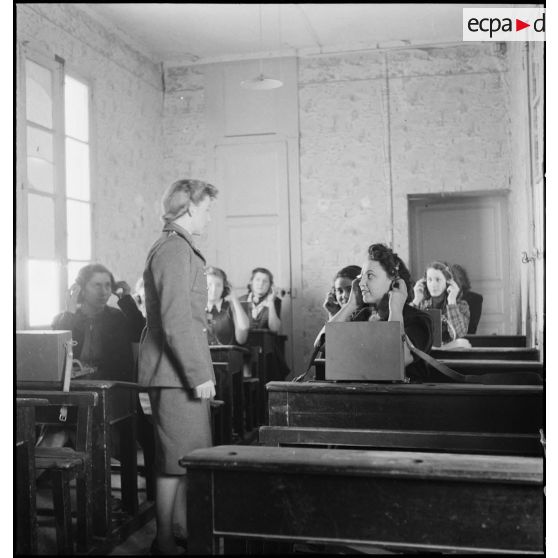 Un lieutenant du corps féminin des transmissions forme des élèves à la télétypie dans un centre de formation.