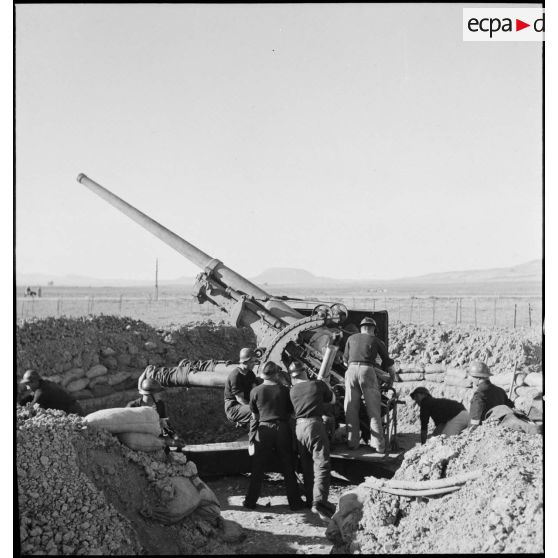 Des canonniers marins, d'une batterie mobile de 90 de marine, approvisionnent un canon de 90 mm, modèle 1939 Schneider antiaérien.