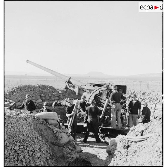 Des canonniers marins, d'une batterie mobile de 90 de marine, approvisionnent un canon de 90 mm, modèle 1939 Schneider antiaérien.