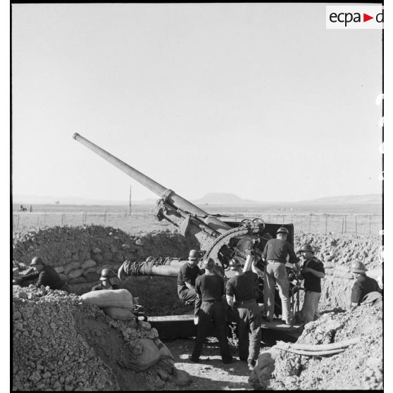 Des canonniers marins, d'une batterie mobile de 90 de marine, approvisionnent un canon de 90 mm, modèle 1939 Schneider antiaérien.