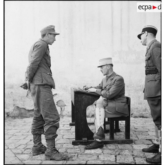 Interrogatoire d'un prisonnier allemand, engagé dans le corps expéditionnaire de l'Afrikakorps, par un chef d'escadrons du 3e RSA (régiment de spahis algériens) de la DMC (Division de marche de Constantine.