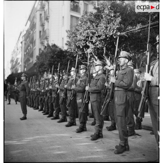 Une unité de l'armée de terre britannique présente les armes lors d'une cérémonie franco-anglo-américaine au monument aux morts d'Alger.