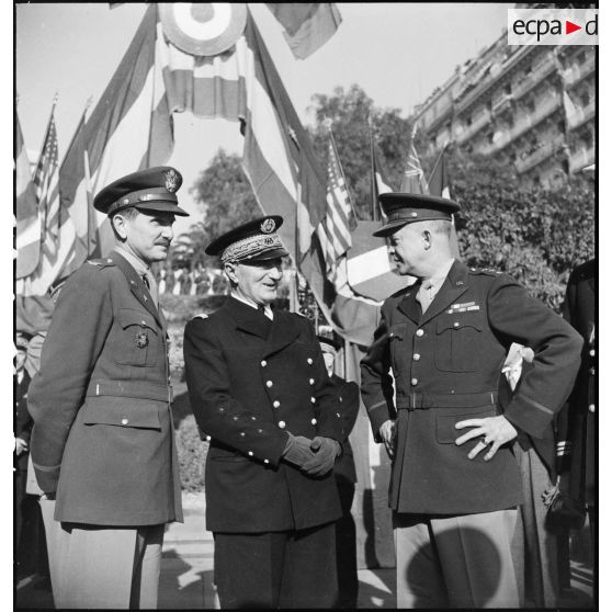 Lors d'une cérémonie franco-anglo-américaine au monument aux morts d'Alger, l'amiral François Darlan, haut-commissaire de France en AFN (Afrique française du Nord), s'entretient avec le lieutenant général Dwight Eisenhower, commandant en chef des troupes alliées en Europe ; à leur côté, un colonel de l'armée de terre américaine.