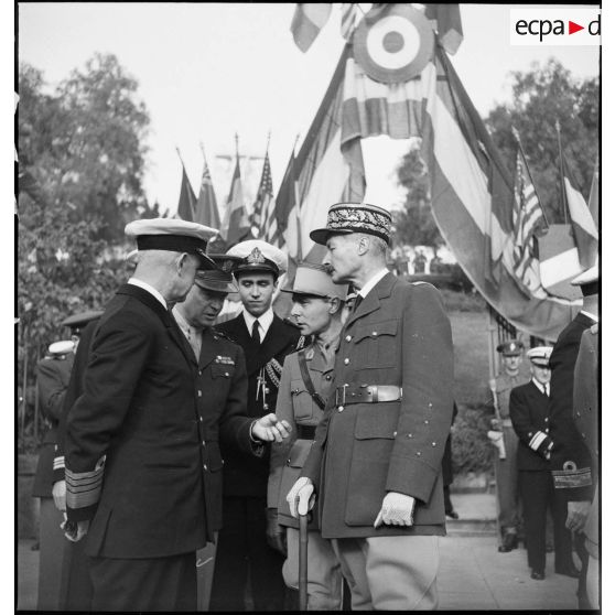 Lors d'une cérémonie franco-anglo-américaine au monument aux morts d'Alger, l'amiral britannique Andrew Cunningham, commandant la flotte en Méditerranée, le lieutenant général Dwight Eisenhower, commandant en chef des troupes alliées en Europe et le général d'armée Henri Giraud, commandant en chef des forces françaises en AFN (Afrique française du Nord), s'entretiennent par l'intermédiaire du capitaine Beaufre.