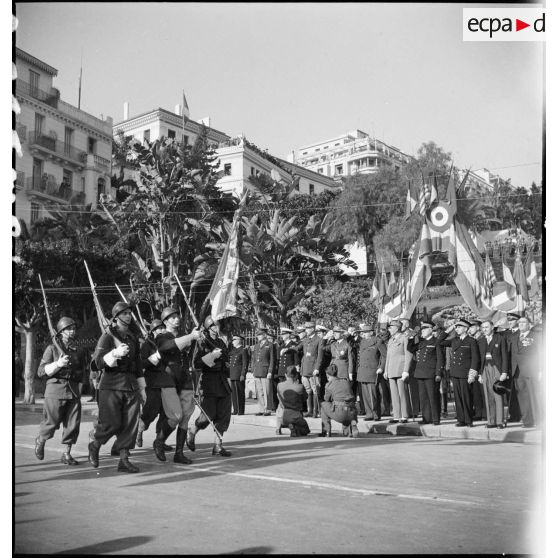 Défilé du drapeau et de la garde d'une unité de l'armée d'Afrique devant les autorités militaires lors d'une cérémonie franco-anglo-américaine au monument aux morts d'Alger.