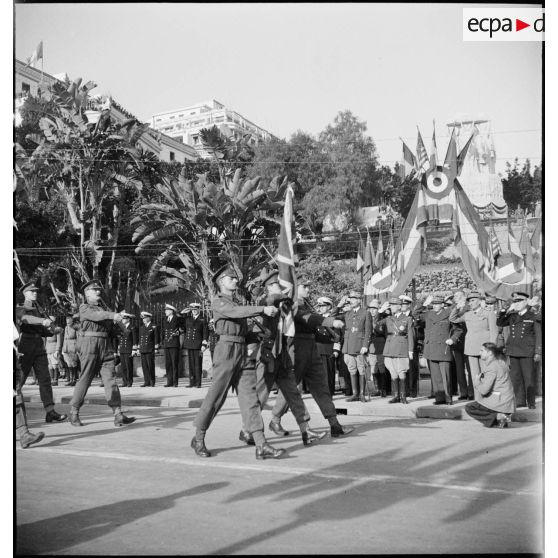 Défilé du drapeau et d'une unité de l'armée de terre britannique devant les autorités militaires lors d'une cérémonie franco-anglo-américaine au monument aux morts d'Alger.