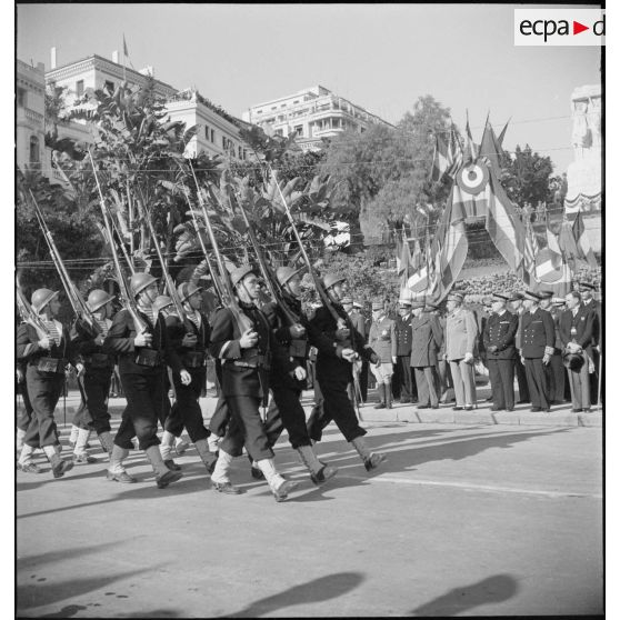 Défilé d'une unité de défense côtière de la marine nationale devant les autorités militaires lors d'une cérémonie franco-anglo-américaine au monument aux morts d'Alger.