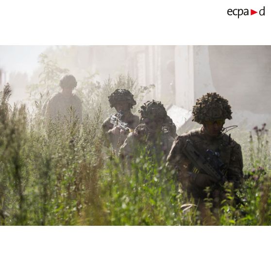 Des soldats britanniques progressent sous couvert de fumigènes sur le camp de Tapa, en Estonie.