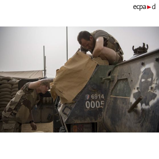 Des soldats aménagent la caisse destinée à accueillir l'eau et la nourriture à bord de leur VBL sur la base de Kidal.