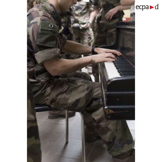 Un saint-cyrien jour du piano dans le hall de la bibliothèque de l'école spéciale militaire (ESM) de Saint-Cyr Coëtquidan.