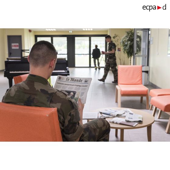 Un saint-cyrien lit un journal dans le hall de la bibliothèque de l'école spéciale militaire (ESM) Saint-Cyr Coëtquidan.