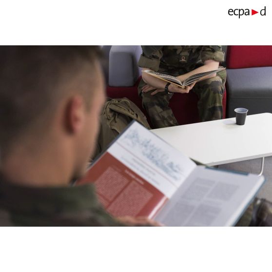 Des saint-cyriens lisent un livre à la bibliothèque de l'école spéciale militaire (ESM) de Saint-Cyr Coëtquidan.