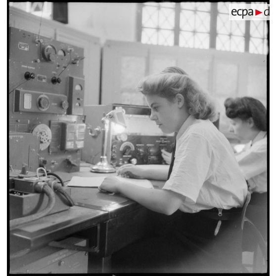 Instruction pratique de TSF pour une élève de l'école des transmissions des personnels féminins de l'armée de l'Air : l'écoute en station.