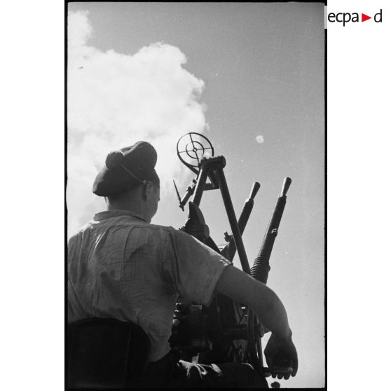 Sous-marinier servant une mitrailleuse double de 13,2 mm CA sur le sous-marin Casabianca.