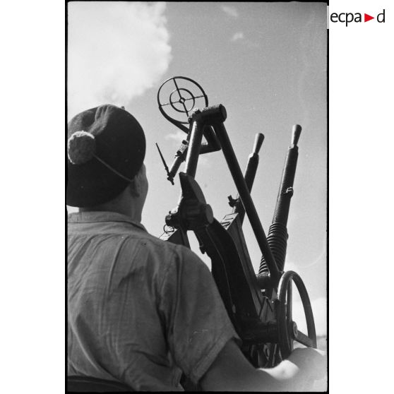 Sous-marinier servant une mitrailleuse double de 13,2 mm CA sur le sous-marin Casabianca.