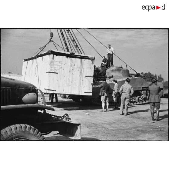 Déchargement d'une caisse de matériel américain, destiné aux troupes françaises, par une grue improvisée montée sur un char Sherman dans le port de Casablanca.