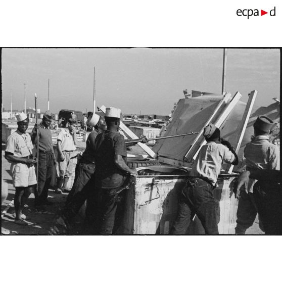 Des soldats des troupes coloniales ouvrent des caisses de matériel contenant des jeeps et des remorques dans le port de Casablanca.