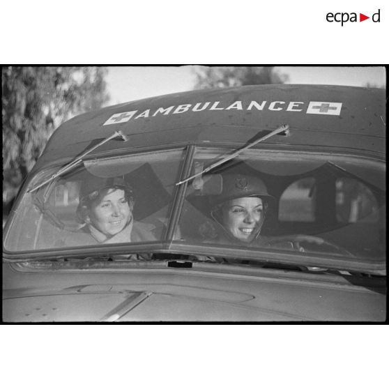 Portrait de groupe de deux volontaires féminines conductrices à la 521e compagnie sanitaire à bord d'une ambulance Dodge T215.