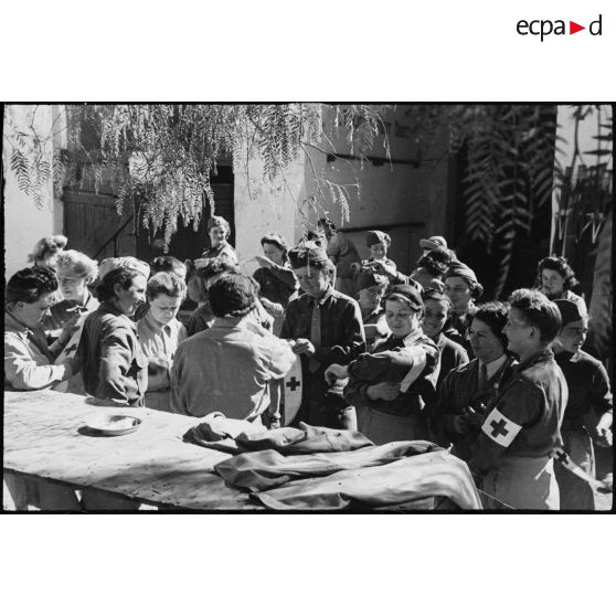 Distribution de brassards aux volontaires féminines conductrices de la 521e compagnie sanitaire dans leur cantonnement.