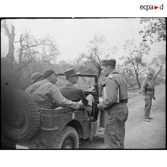 Les généraux Juin et De Gaulle s'entretiennent avec un officier.