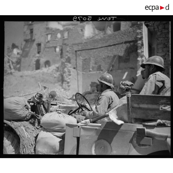 L'équipage d'un Dodge, équipé de masques M1 antipoussière, d'un élément avancé de la 4e DMM (division de marche marocaine), traverse le village de Vallecorsa.