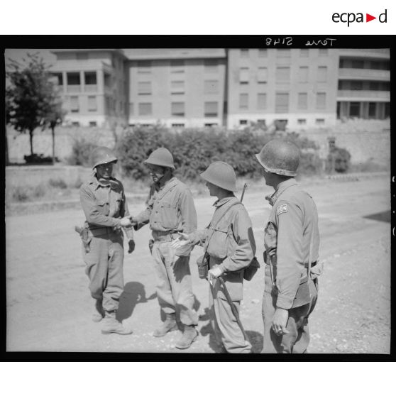 Deux officiers du 2e corps d'armée américain saluent des tirailleurs français, appartenant probablement au 3e RTA (régiment de tirailleurs algériens) de la 3e DIA (division d'infanterie algérienne). Les troupes américaines et françaises font une jonction à Colleferro.