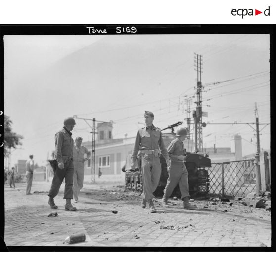 Revenant des faubourgs de Rome, le lieutenant general Mark Wayne Clark, commandant la 5e armée américaine, accompagné de certains de ses grands subordonnés, regagne son poste de commandement ; à droite, le major general Geoffrey Keyes, commandant le 2e corps d'armée.