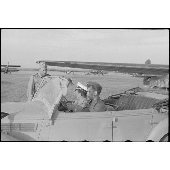 A bord d'un cabriolet Auto-Union, un capitaine (peut-être l'Hauptmann Joseph Karl) Gruppenkommandeure III./LLG.1 inspecte l'aérodrome de Valence-Chabeuil (Drôme) avant une mission.