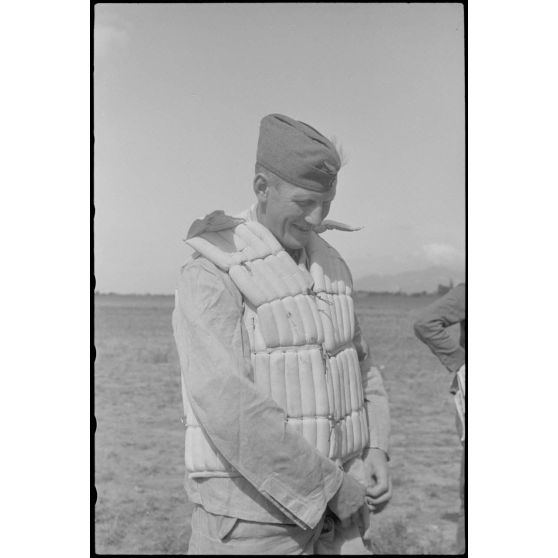 Sur l'aérodrome de Lézignan-Corbières, un membre du Sondergruppe du Luftlandegeschwader 1 (groupe aéroporté) s'équipant d'un gilet de sauvetage.